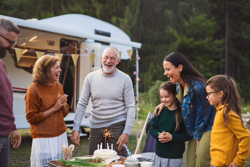 A family camping and celebrating with cake and candles