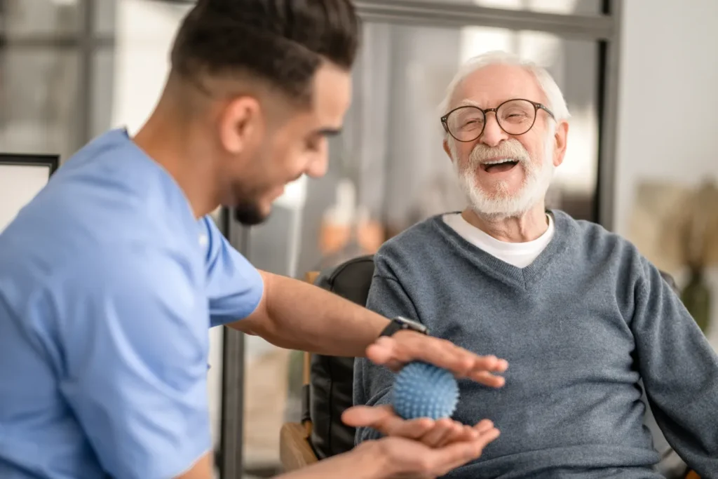 Physical therapist working on hand strength and mobility with older patient